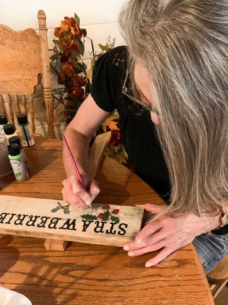 Stephanie Ray hand paints strawberries on DIY Farmhouse Garden Sign